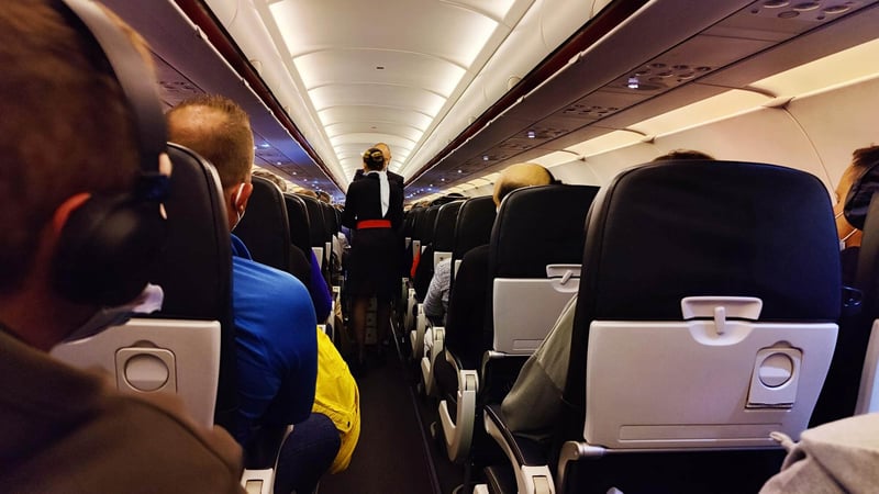 interior-airplane-with-passengers-seats-stewardess-uniform-walking-aisle-1