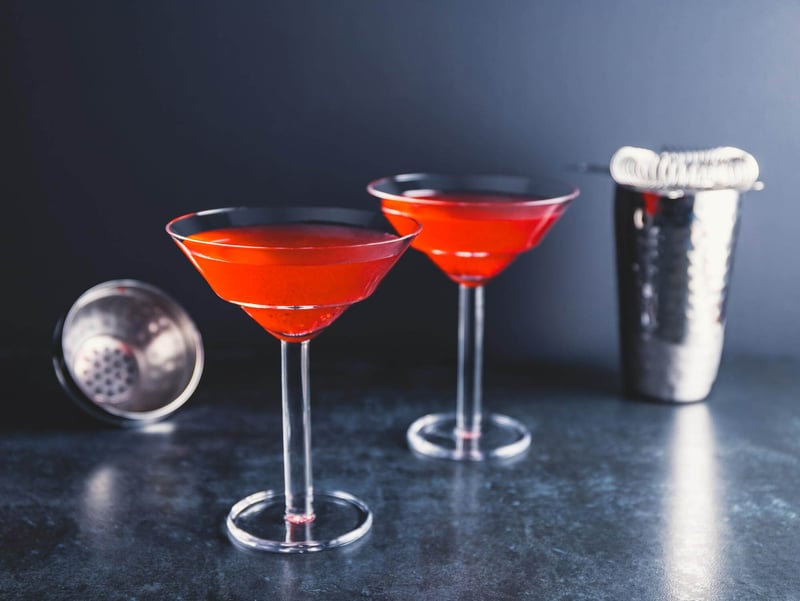 red-cocktail-with-lime-martini-glass-table