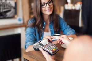 smiling-woman-paying-coffee-by-credit-card